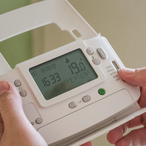 manos ajustando la temperatura de la casa del termostao digital